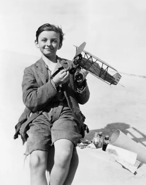 Egy fiú, egy Repülőmodell gazdaság, és mosolyogva portréja — Stock Fotó
