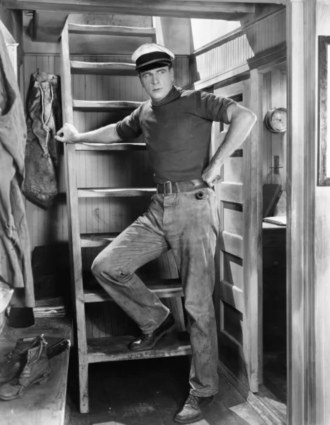Hombre apoyado en una escalera — Foto de Stock
