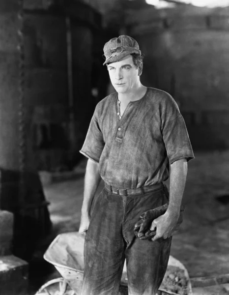 Bir el arabası duran inşaat işçisi — Stok fotoğraf