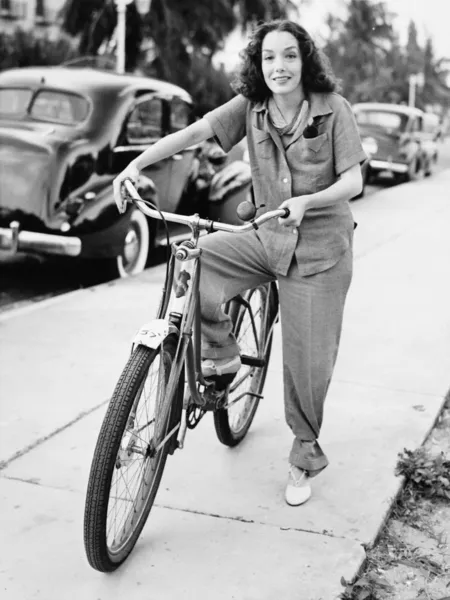 自転車を保持していると笑みを浮かべて若い女性の肖像画 — ストック写真