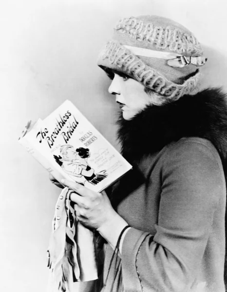 Perfil de uma jovem mulher lendo um livro — Fotografia de Stock