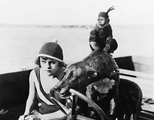 Девушка-подросток, сидящая на моторной лодке за рулем собаки — стоковое фото