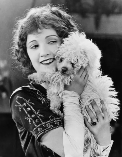 Mujer joven jugando con su perro y sonriendo — Foto de Stock