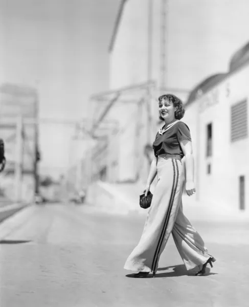 Молодая женщина, идущая через дорогу — стоковое фото