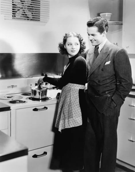 Perfil de una joven cocinando comida con un joven — Foto de Stock