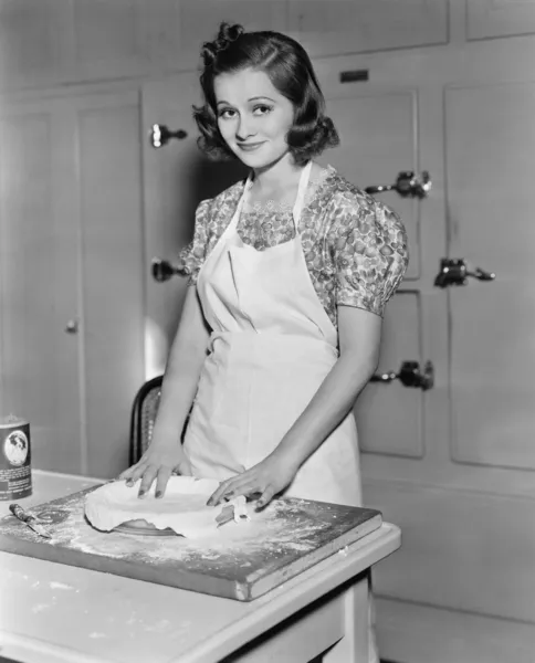Młoda kobieta przygotowuje jedzenie w kuchni — Zdjęcie stockowe