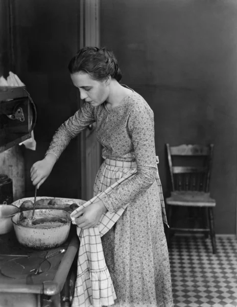 Perfil de una joven cocinando comida en la cocina — Foto de Stock
