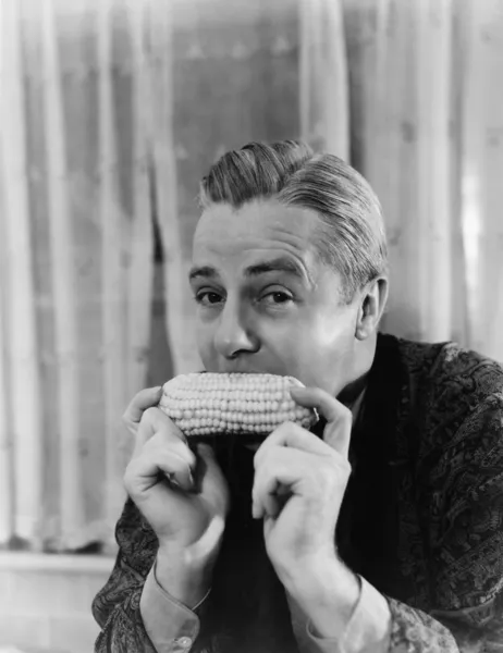 Портрет человека, поедающего кукурузный початок — стоковое фото