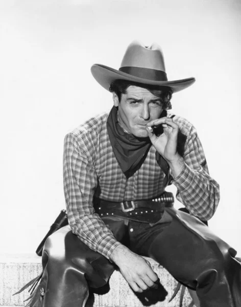 Vaquero con sombrero de vaquero fumando un cigarrillo — Foto de Stock