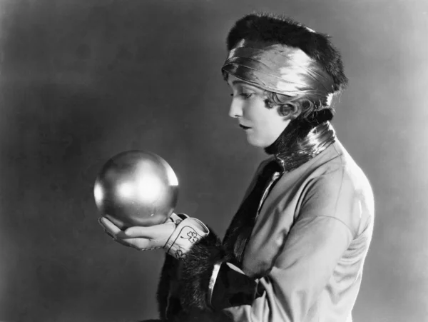 Perfil de una mujer sosteniendo una bola de metal — Foto de Stock