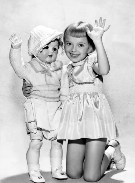 Portret dziewczyny, klęcząc i trzyma lalkę lifesize — Zdjęcie stockowe