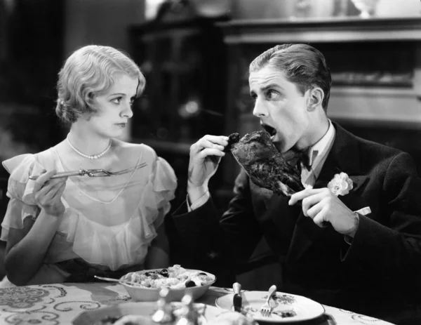 Мужчина ест жареную индейку с женщиной — стоковое фото