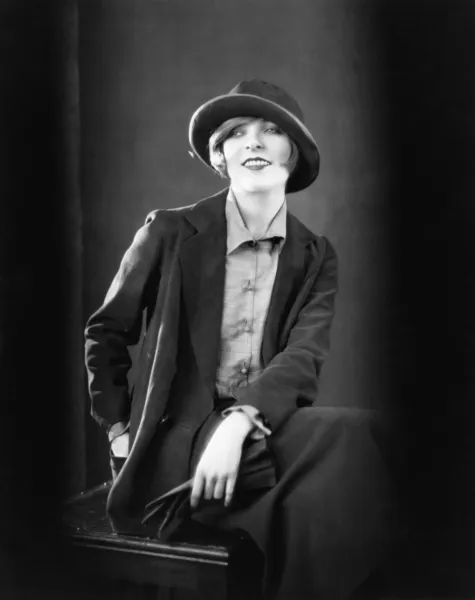 Porträt einer Frau, die auf einem Schemel sitzt und lächelt — Stockfoto