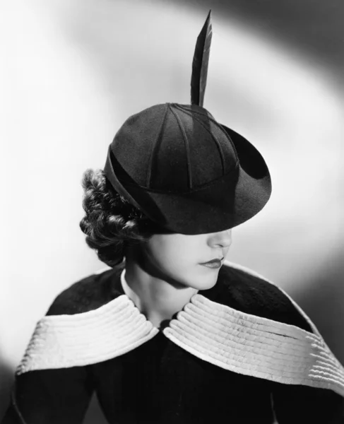 Portrait of a young woman wearing a hat with a feather — Stock Photo, Image