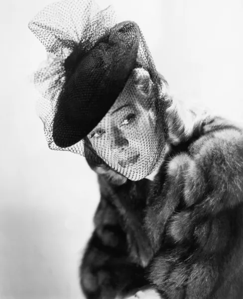 Portrét mladé ženy nosí kožichu a klobouk se závojem — Stock fotografie