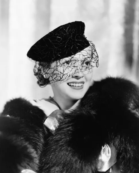 Ritratto di una giovane donna con un cappello con un velo e una pelliccia rubata sorridente — Foto Stock