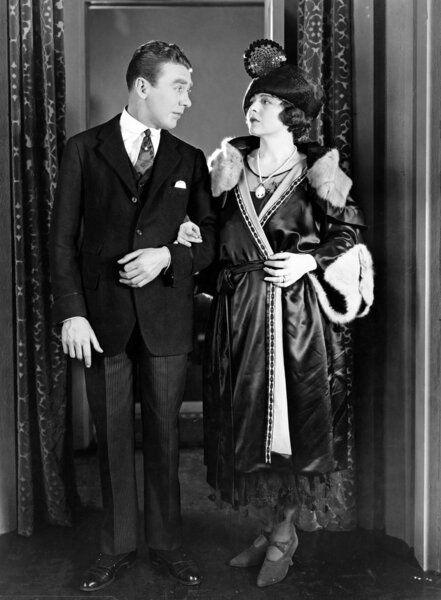 Couple standing arm in arm and looking at each other