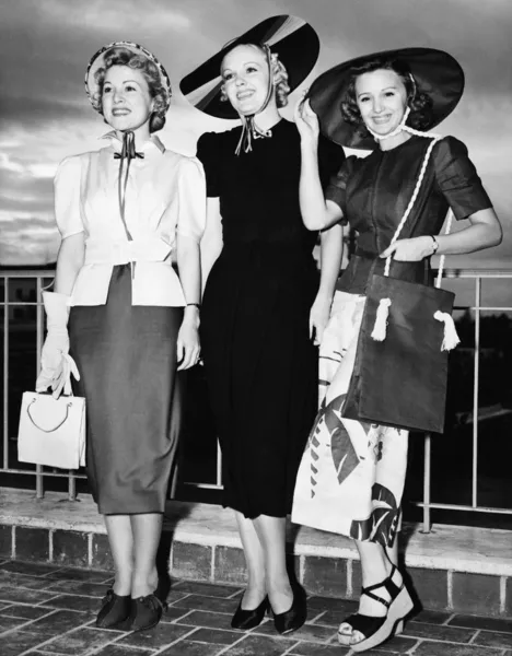 Three young women standing side by side and smiling — Stock Photo, Image