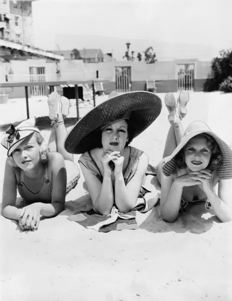 Portret van drie jonge vrouwen liggend op het strand — Stockfoto
