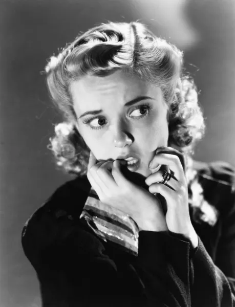 Πορτρέτο μιας νεαρής γυναίκας δάγκωμα των νυχιών της και ψάχνει φοβισμένη — Φωτογραφία Αρχείου