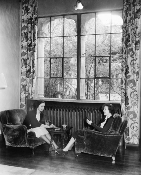 Two women playing cards and sitting together