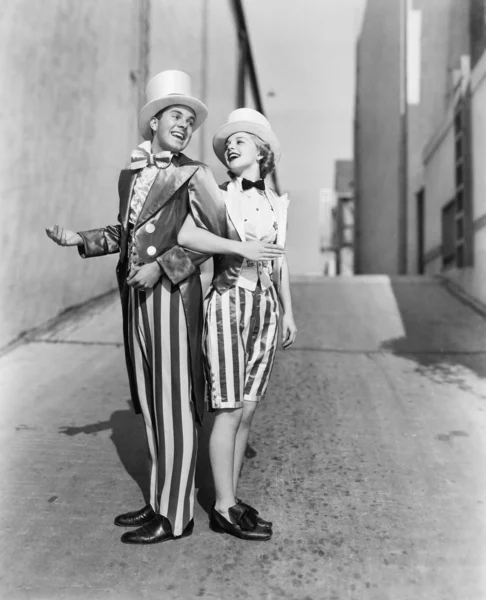 Perfil de um jovem e uma jovem mulher de pé de braço dado em um traje — Fotografia de Stock