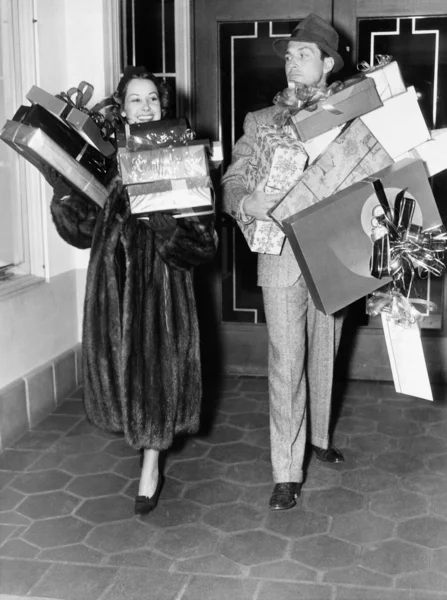 Paar geht und hält Stapel von Geschenken — Stockfoto