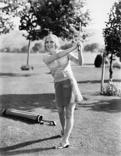 Mujer jugando al golf en un campo de golf — Foto de Stock