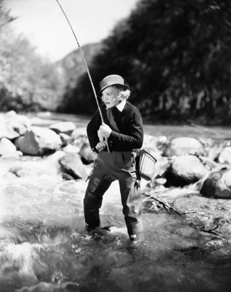年轻女子在河里钓鱼 — 图库照片