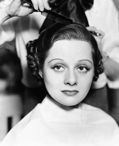 Kadeřník česání vlasů mladé ženy — Stock fotografie