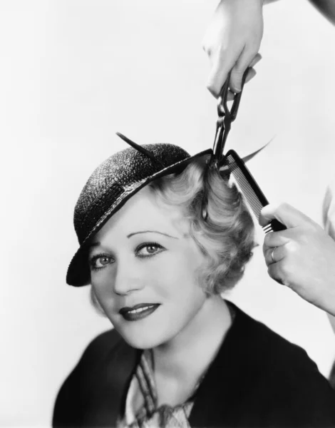 Porträtt av en ung kvinna att få håret krullat med ett strykjärn — Stockfoto