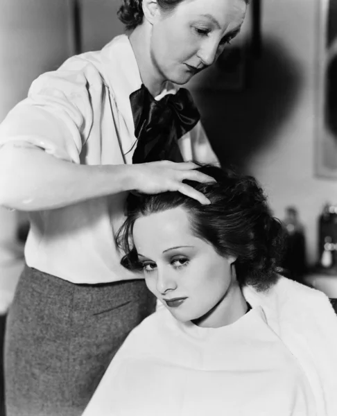 Mujer joven haciendo su peinado en una peluquería —  Fotos de Stock