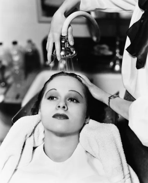 Utsikt över en kvinnlig frisör tvätta hår av en ung kvinna i en frisörsalong — Stockfoto