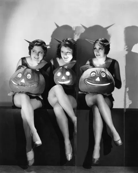Três jovens mulheres sentadas e segurando Jack O 'Lanternas em suas voltas — Fotografia de Stock
