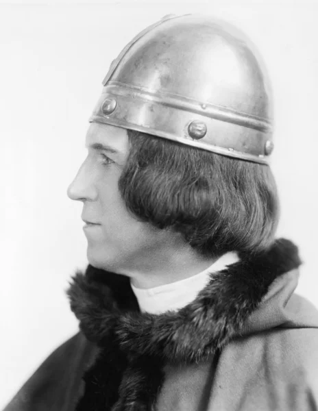 Portrait of a man in costume and a helmet looking away — Stock Photo, Image