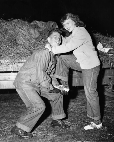 Portrait of a young man helping a young woman board a trailer