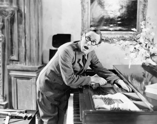 Uomo che grida con la mano incastrata in un pianoforte — Foto Stock
