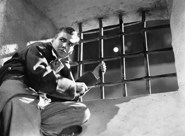 Vue en angle bas d'un jeune homme essayant de s'échapper d'une cellule de prison — Photo