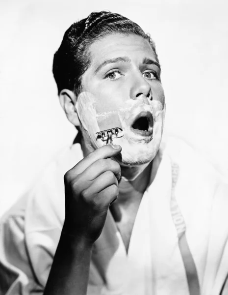 Portrait of a young man shaving — Stock Photo, Image
