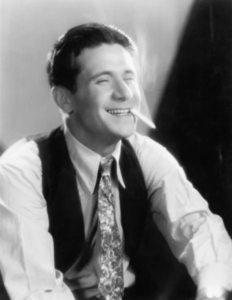 Νεαρός άνδρας, γελώντας και καπνίζει ένα τσιγάρο — Φωτογραφία Αρχείου