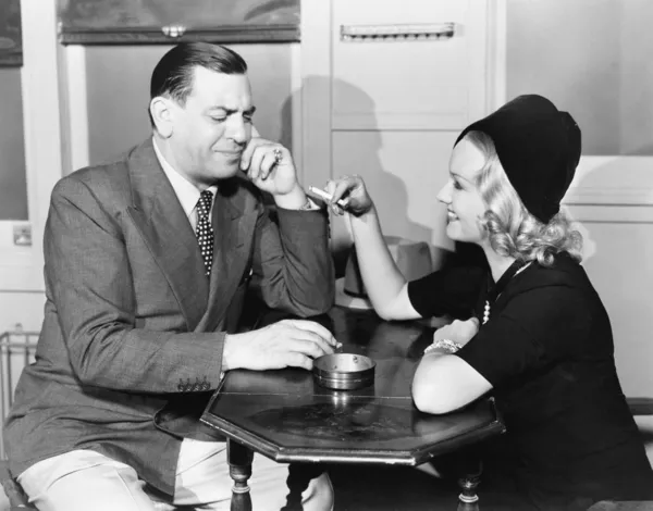 一个男人和一个年轻女人吸烟坐在一家咖啡馆的侧影 — 图库照片