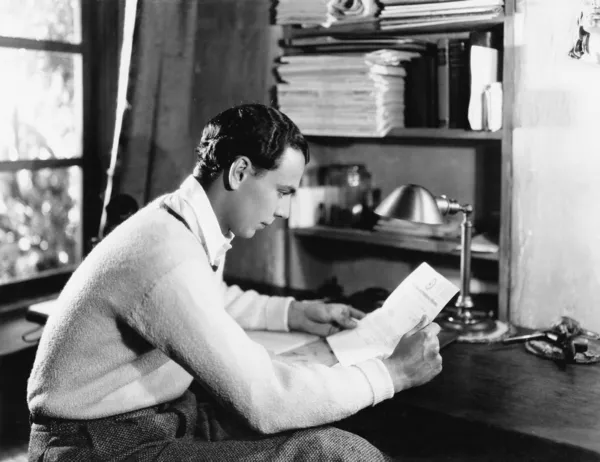 Young man reading a paper — Φωτογραφία Αρχείου