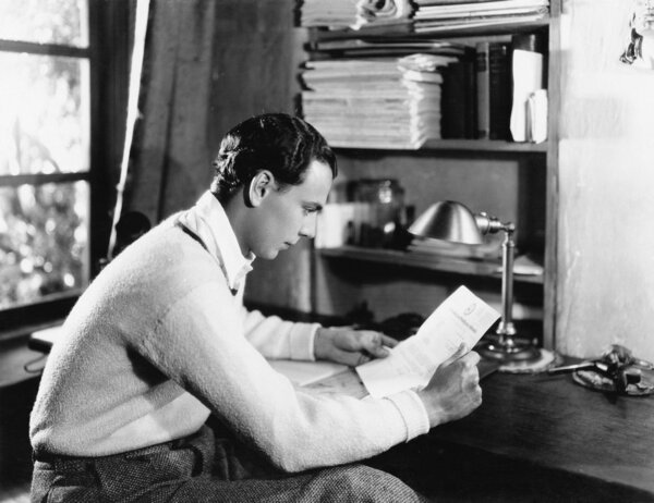 young man reading a paper