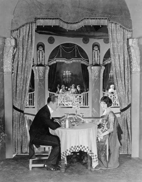 Perfil de una pareja sentada en una mesa en un restaurante cenando — Foto de Stock