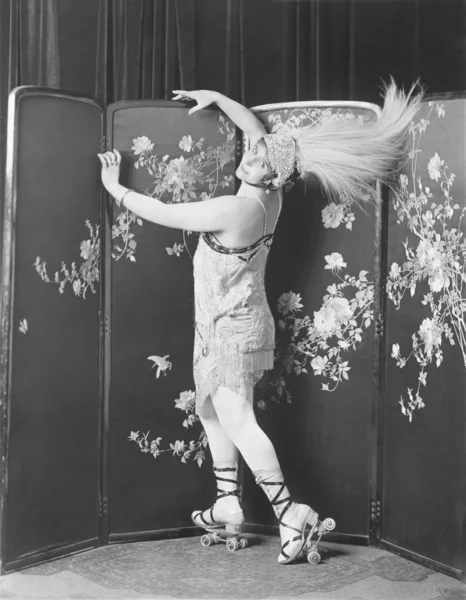 Perfil de uma jovem mulher usando patins usando um chapéu de penas — Fotografia de Stock