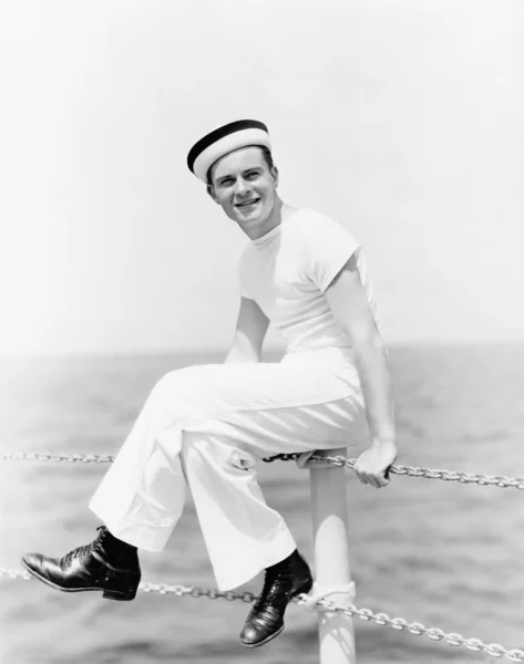ボートのポールの上に座ってと笑みを浮かべて船員の肖像画 — ストック写真