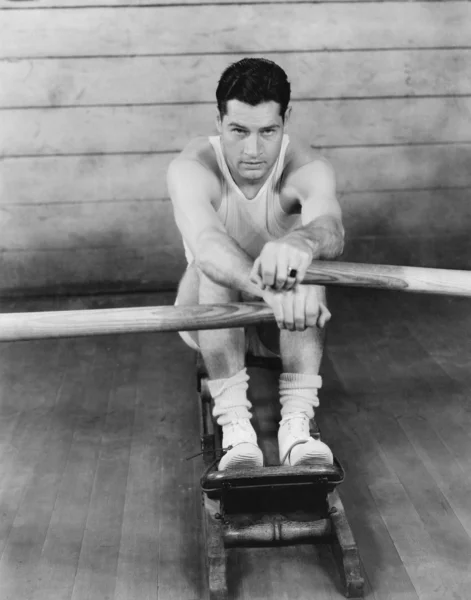 Porträt eines jungen Mannes, der auf einem Rudergerät trainiert — Stockfoto