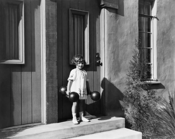 Dívka drží činky a přede dveře — Stock fotografie