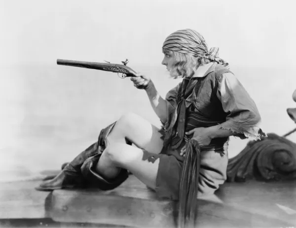 Perfil de uma jovem mulher segurando um pistilo flintlock em uma roupa de piratas — Fotografia de Stock