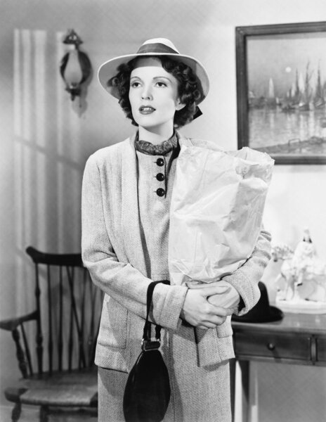 Молодая женщина держит сумку с покупками
